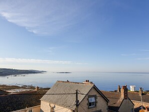 A coastal house with a tiled roof, a chimney, and a small window. - Ocean View (Marazion)