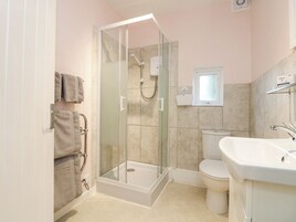 Un baño con ducha de vidrio, inodoro y lavamanos.