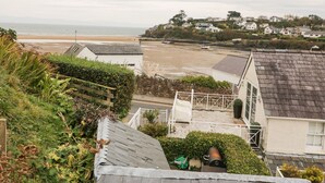 A coastal residential area with houses, a beach, and a view of the sea. - Castell (Pwllheli)