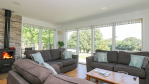 A living room with two sofas, a coffee table, and a fireplace. - Willow (Truro)