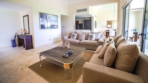 Una sala de estar moderna con un sofá, una mesita de centro y un amplio ventanal.