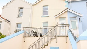 Ein zweistöckiges Wohngebäude mit Treppe und Balkon.
