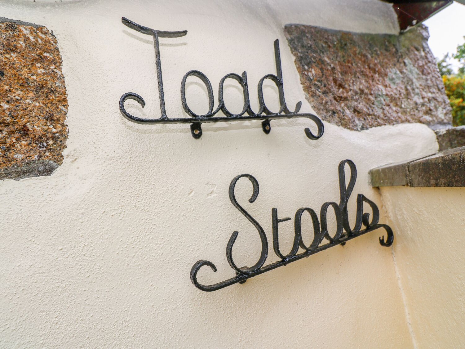 Una señal con la inscripción 'Toad Stods' sobre una pared con textura.
