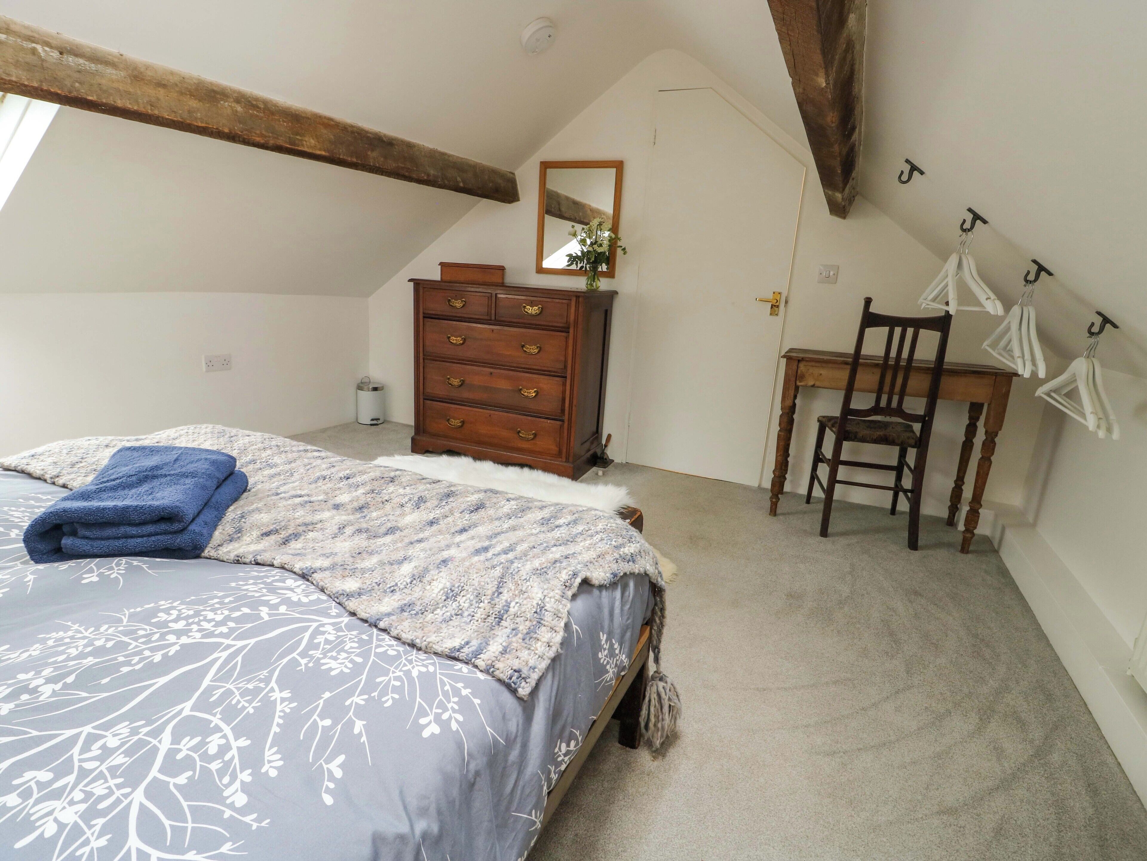A bedroom with a bed, a dresser, a chair, and a desk.