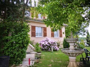 A house with a garden, a fountain, and a staircase leading to the entrance. - Au Jardin Fleuri (Azay-sur-Thouet)