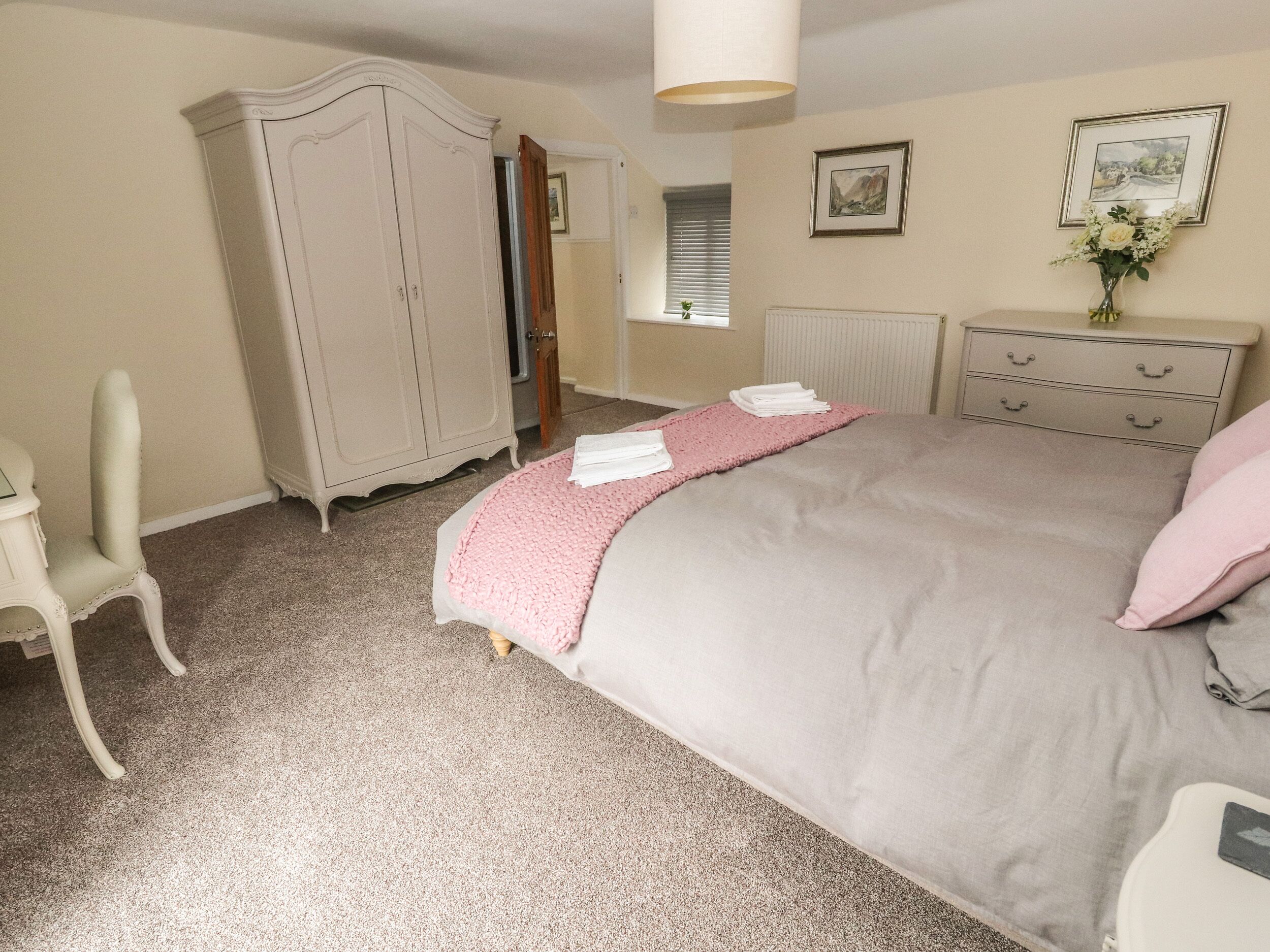 A bedroom with a bed, a wardrobe, a dresser, and a chair.