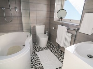 Ein modernes Badezimmer mit freistehender Badewanne, Toilette und Waschbecken.