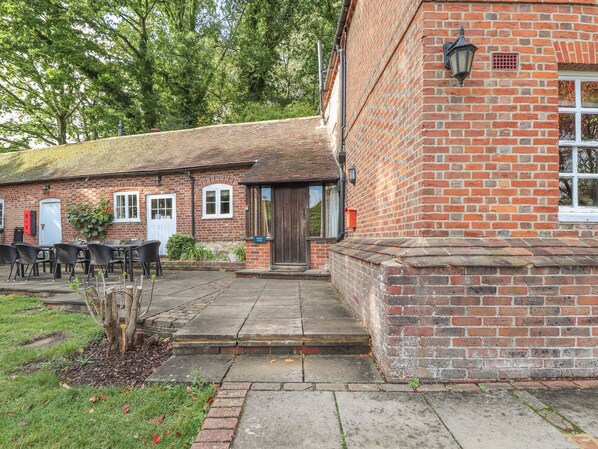 A brick building with a tiled roof, a wooden door, and a small porch area with steps leading to the entrance. - Keepers House (Maidstone)