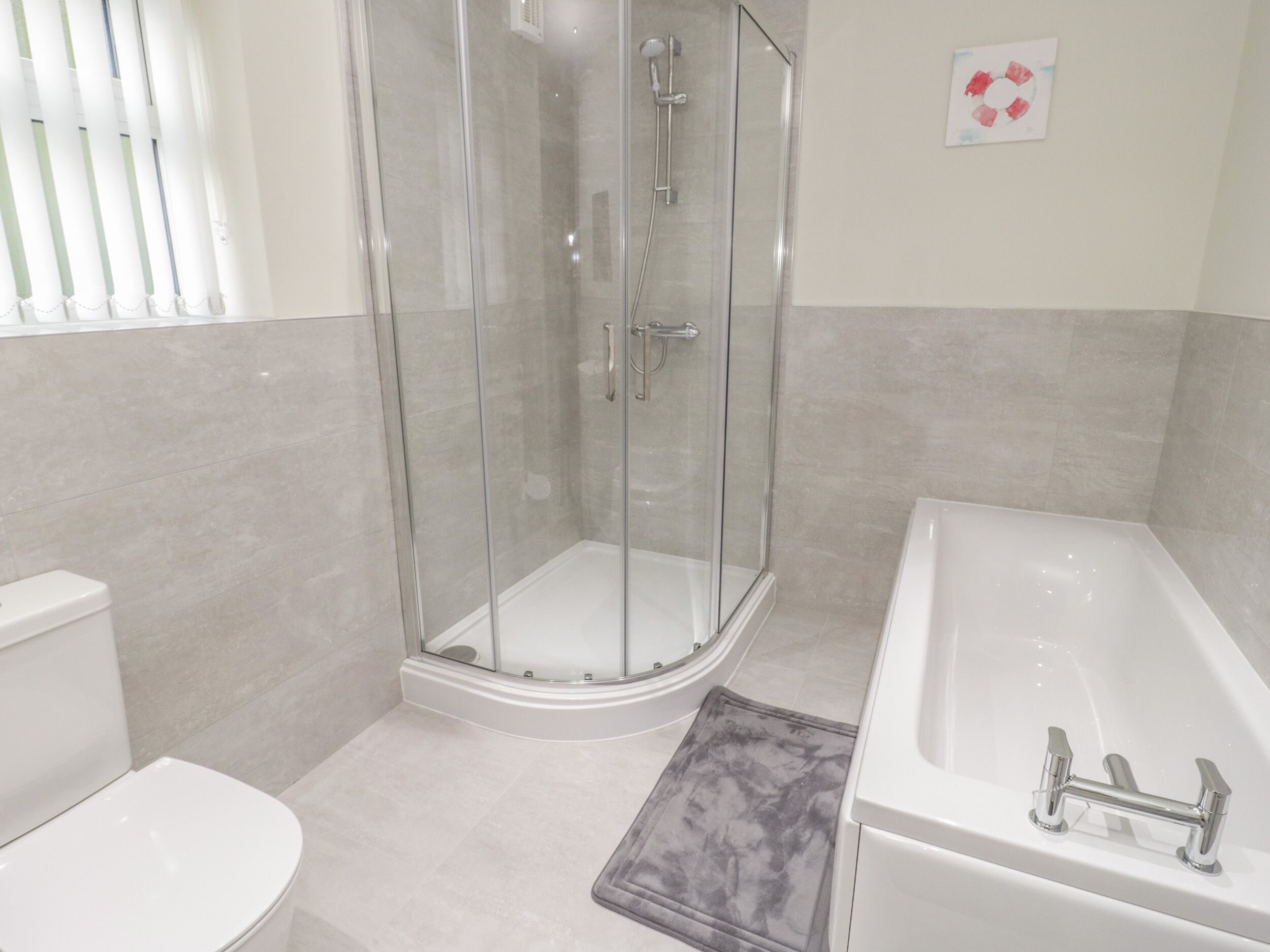 Un baño moderno con ducha de vidrio, inodoro blanco y bañera.