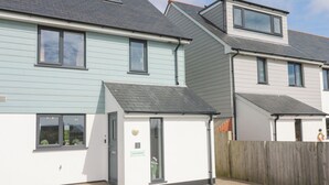 A row of modern two-story houses with a small attached garage. - Ocean Breeze (Marazion)