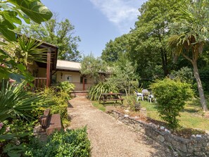 A rustic building with a gravel pathway leading to a wooden deck. - Riverhouse Lodge (Weymouth)