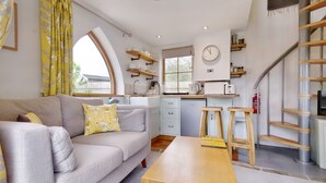 A modern kitchen with white cabinets, a wooden table, and a built-in stove. - The Folly (Hereford)