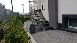 Una escalera conduce a un edificio con una hoguera y vistas de la ciudad.