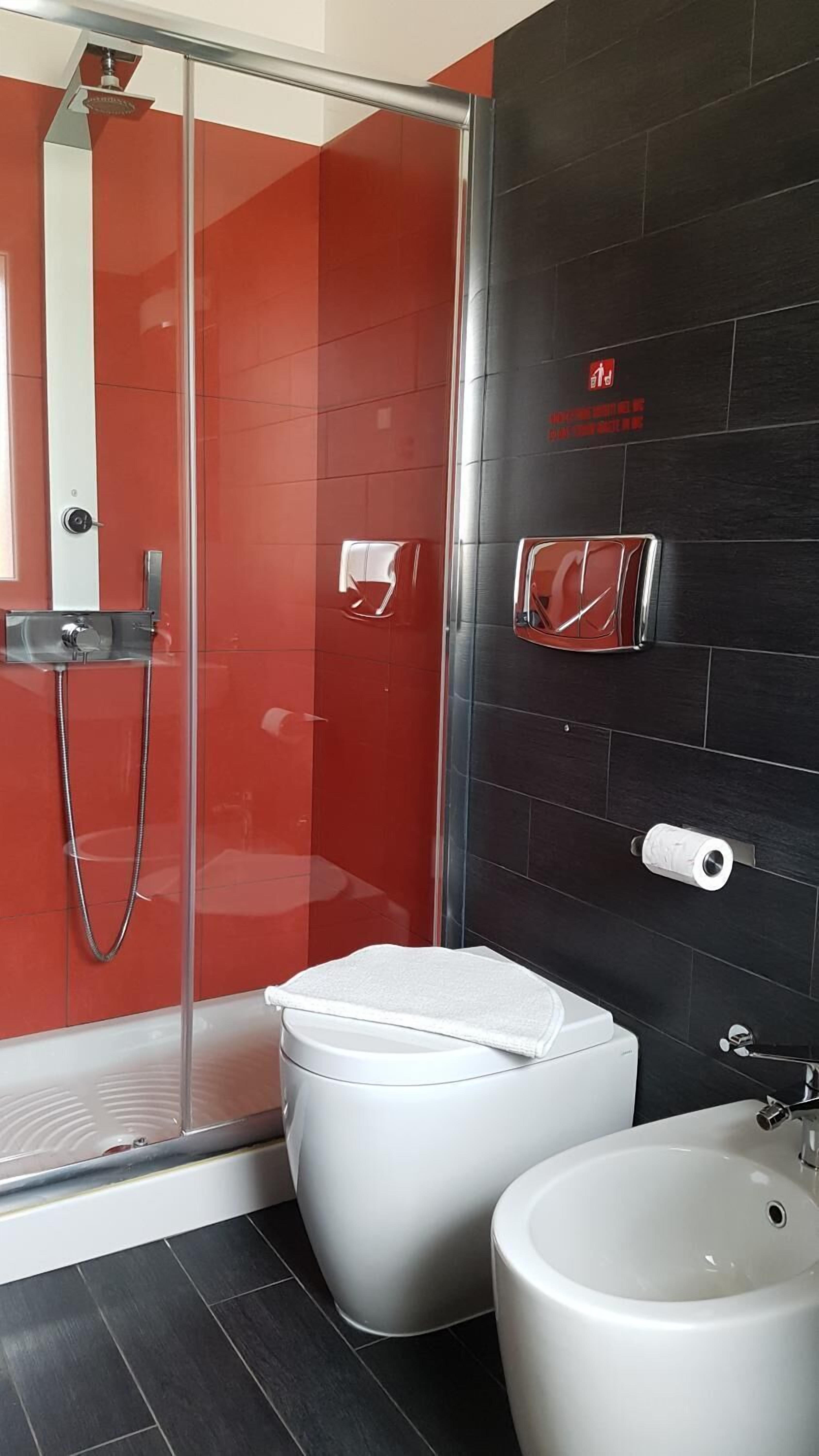 Un baño moderno con cabina de ducha de vidrio, inodoro y bidé.