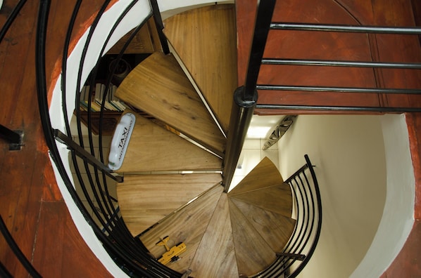 Una escalera de caracol con escalones de madera y barandillas de metal.