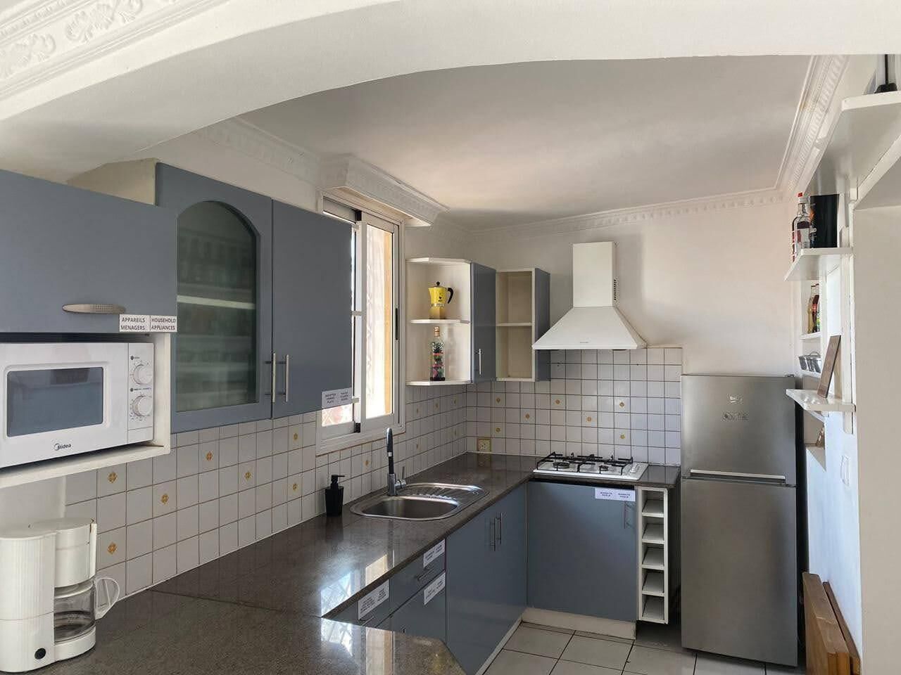 A modern kitchen with a microwave, stove, sink, and refrigerator.