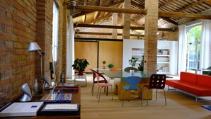 A spacious room with exposed brick walls, a wooden ceiling, and a bright, open layout. - InVento bnb (Civitanova Marche)