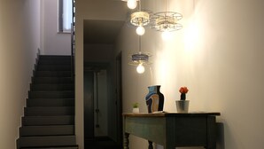 A staircase leading to a landing with a table and a vase of flowers. - InVento bnb (Civitanova Marche)