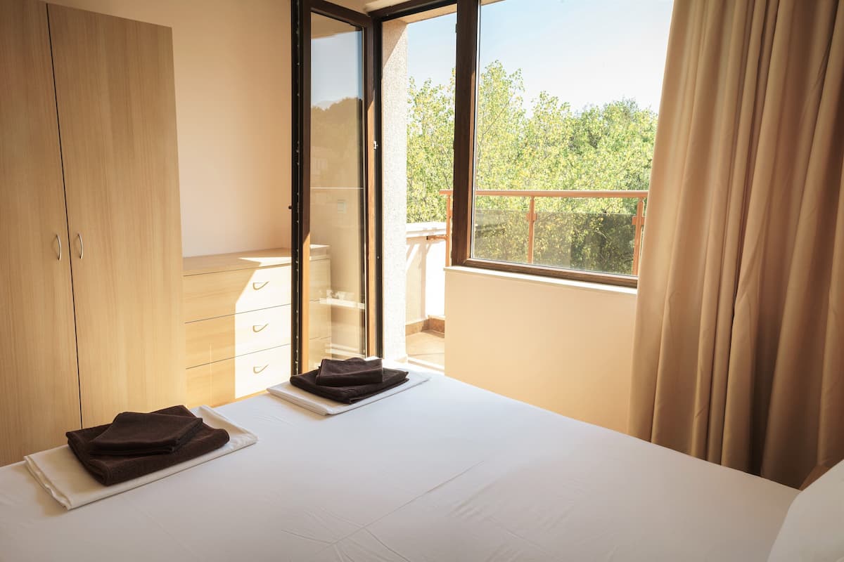 Ein Hotelzimmer mit Bett, Kleiderschrank, Bad und einem Balkon mit Blick.