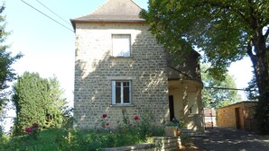 A stone building with a small window and a door, surrounded by greenery and a stone wall. - La Maison Blanche: private heated pool, 7 bedrooms (Sarlat-la-Canéda)