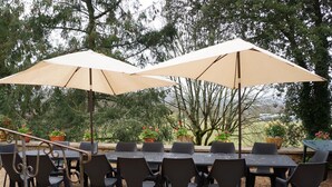 An outdoor patio with a table and chairs, shaded by two large umbrellas. - La Maison Blanche: private heated pool, 7 bedrooms (Sarlat-la-Canéda)