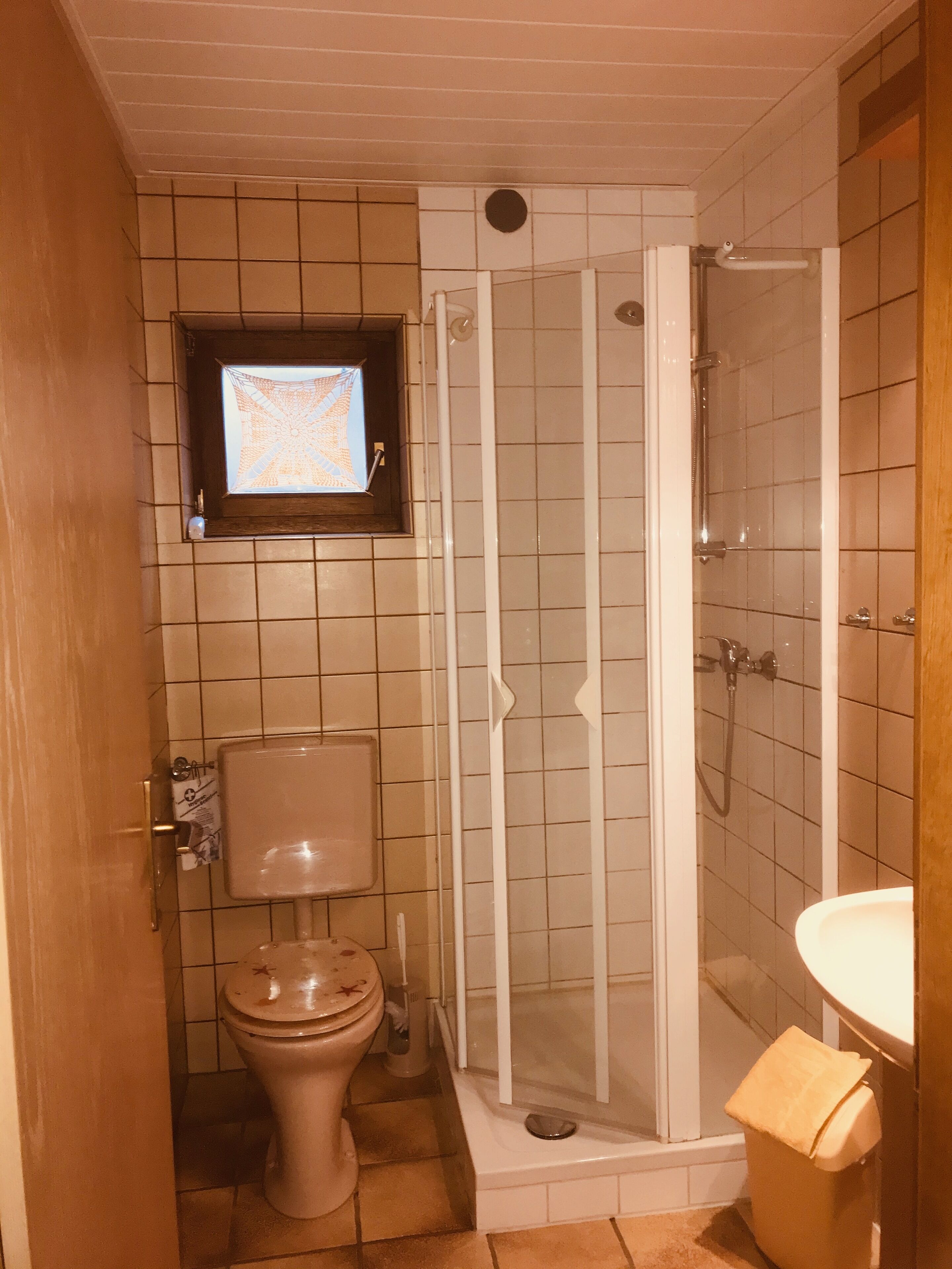 A bathroom with a toilet, a shower enclosure, and a sink.