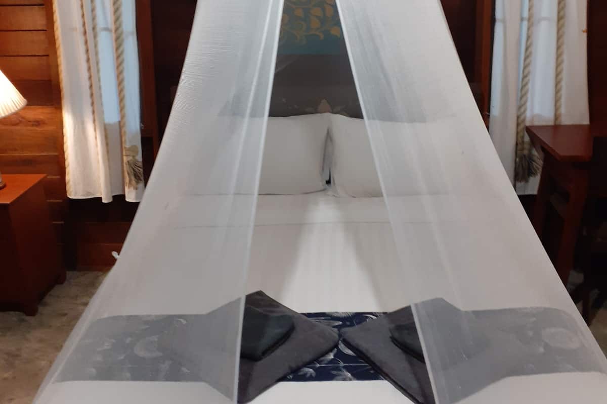 A bed with a canopy, wooden walls, and curtains.