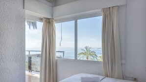 A hotel room with a large window, a bed, and a view of the sea. - Skol Sea Views Apartments (Marbella)
