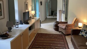 A living room with a sofa, a coffee table, a TV, and a patterned rug. - Stunning Medieval Mountain Retreat With Pool (Castelbianco)