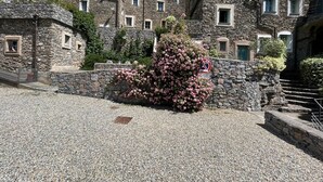 A stone building with multiple windows and a gravel driveway. - Stunning Medieval Mountain Retreat With Pool (Castelbianco)