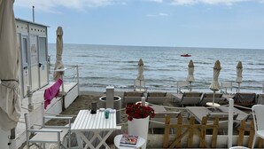 A beachside terrace with white furniture, a table with a magazine, and a flower pot. - Stunning Medieval Mountain Retreat With Pool (Castelbianco)