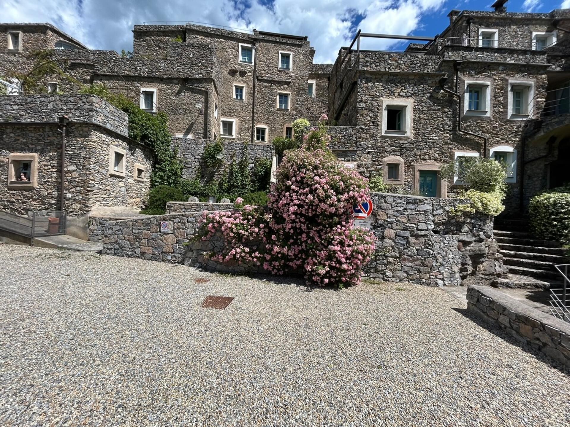 Un edificio de piedra con varias ventanas y un camino de entrada de grava.