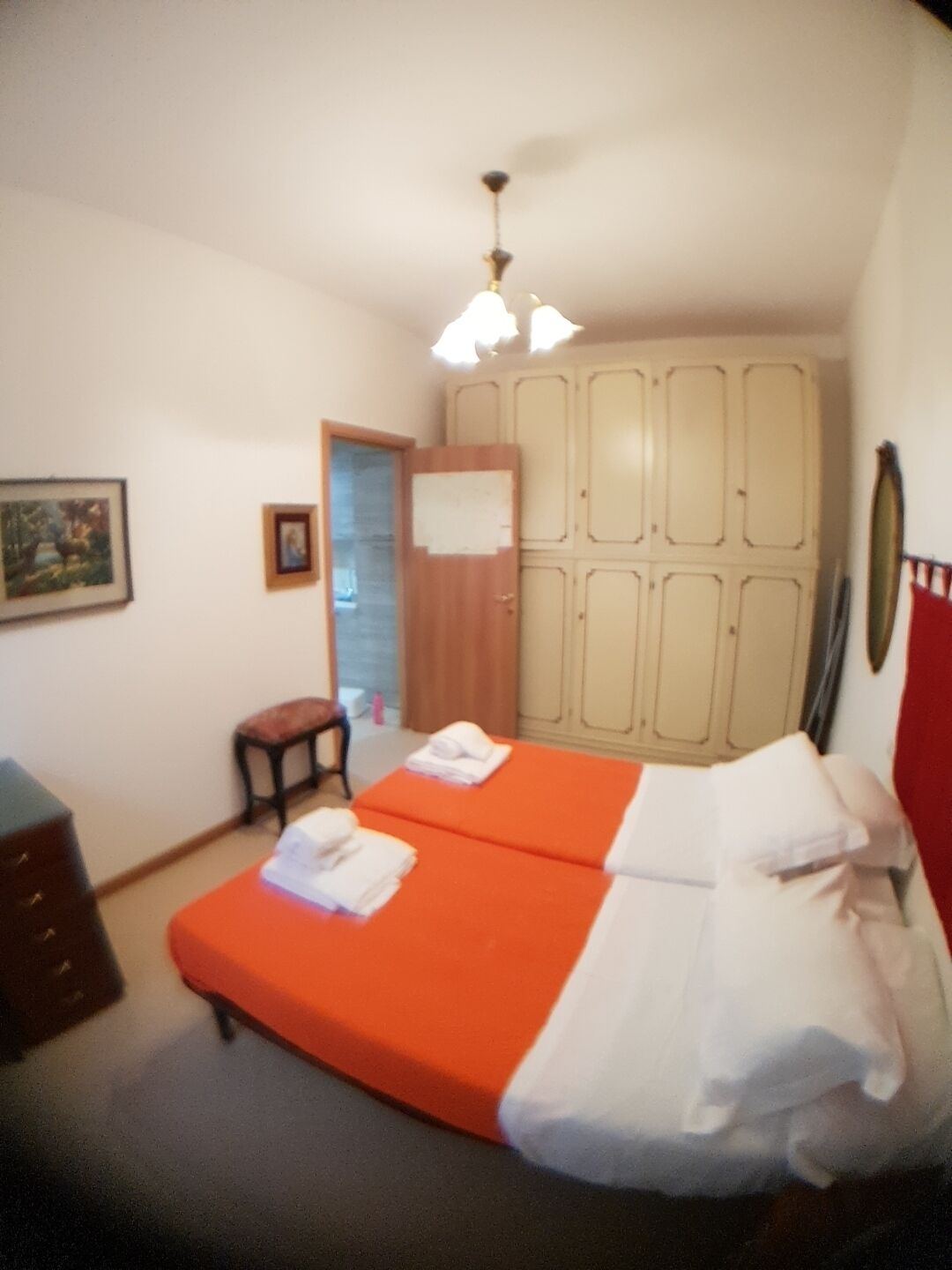 A room with two beds, a desk, a chair, and a wardrobe.