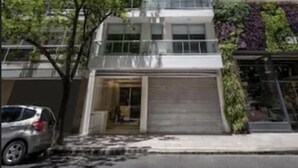Un edificio moderno de varios pisos, con techo plano y amplias ventanas.