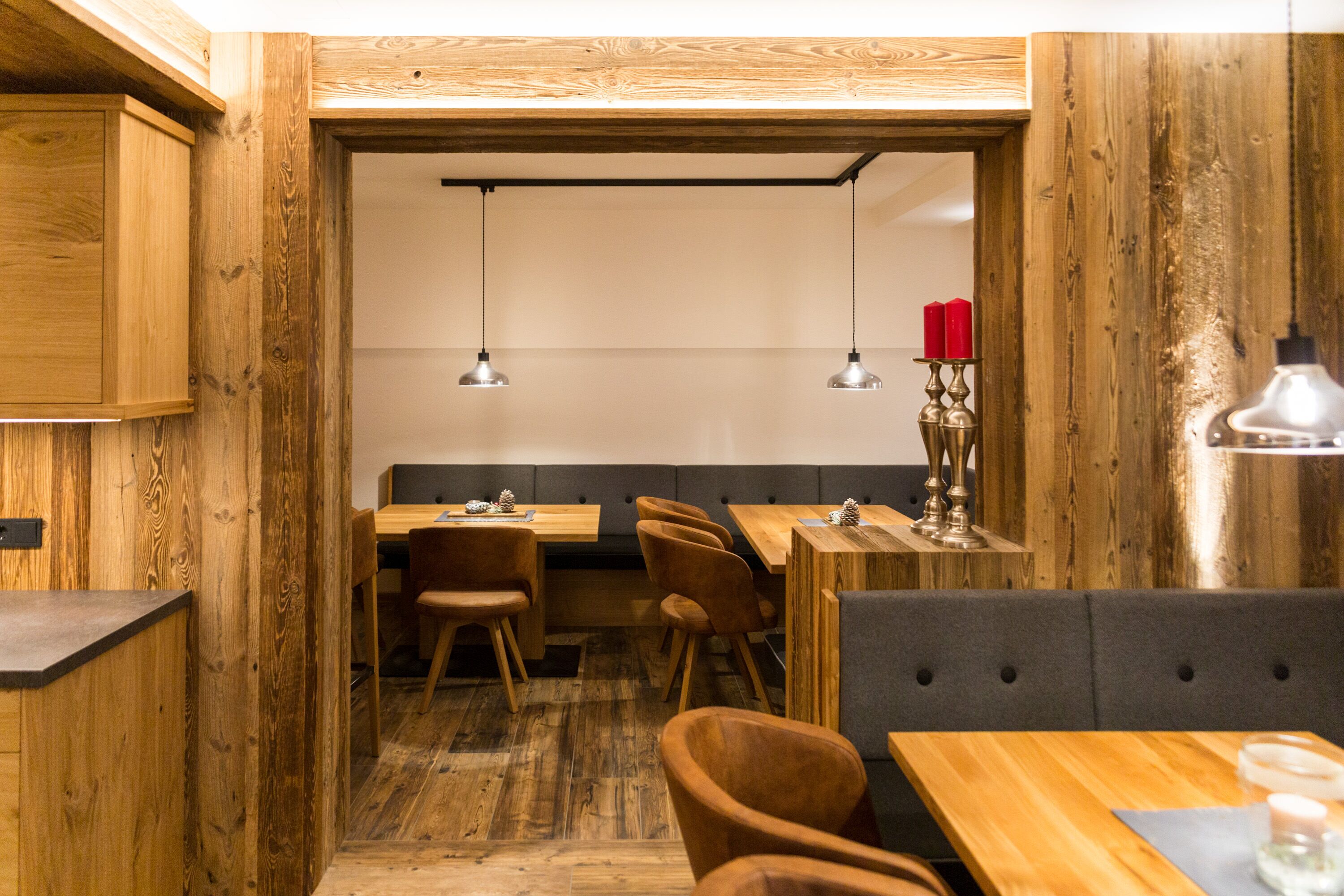 Ein Restaurant mit Holzwänden und -möbeln, mit Tischen und Stühlen.