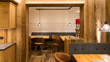 Un restaurante con paredes y muebles de madera, que incluye mesas y sillas.