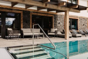 Una piscina al aire libre, sombrillas, tumbonas