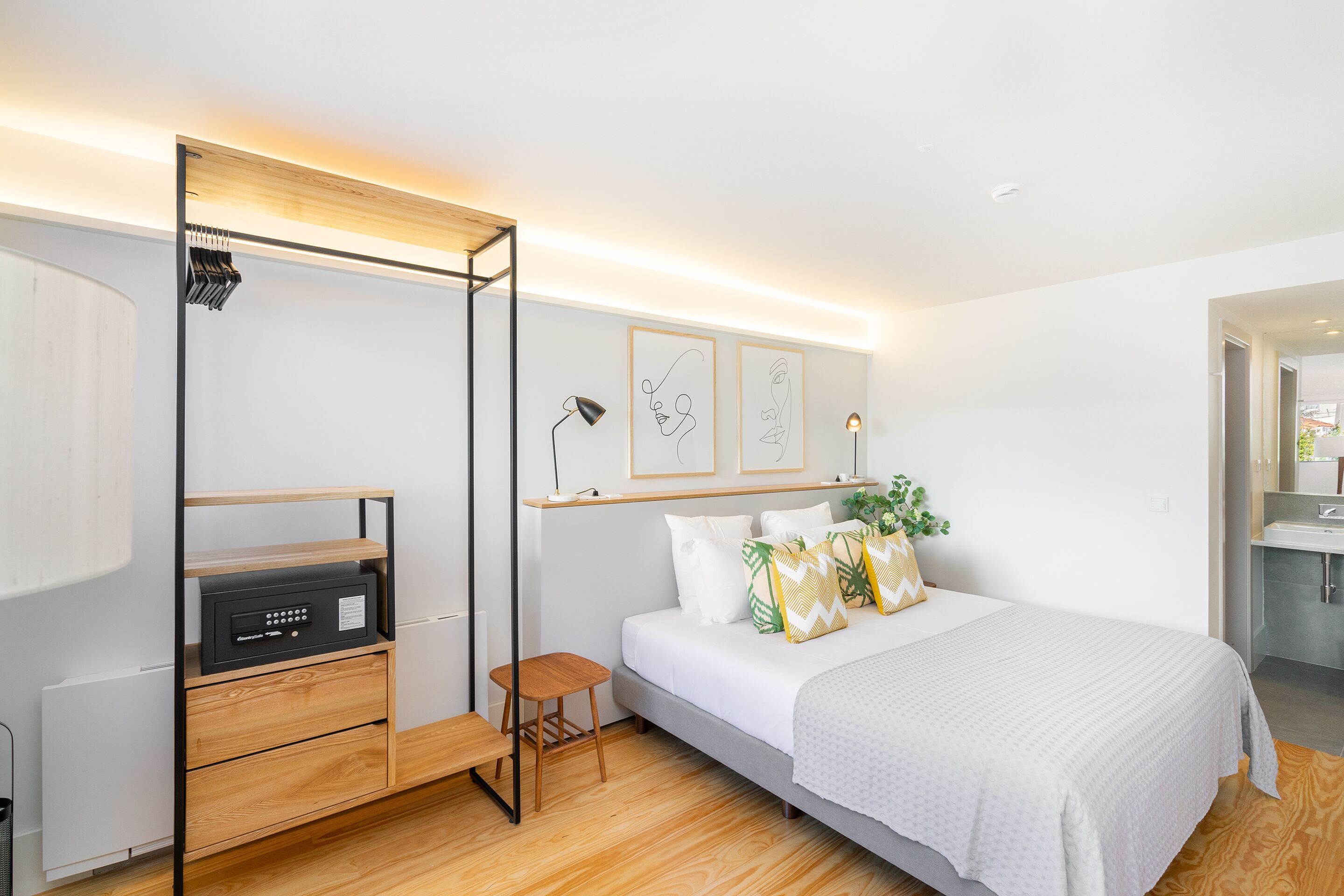 A modern bedroom with a bed, bedside table, and a built-in heater.