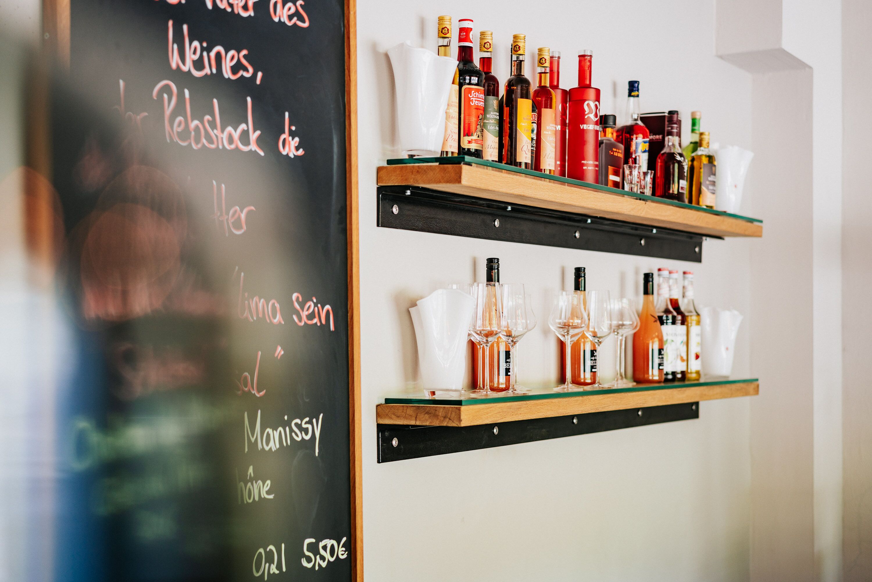 A bar area with shelves of liquor bottles and glasses.