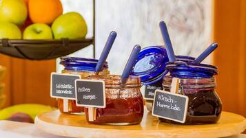Barattoli di marmellata con etichette su un vassoio di legno.