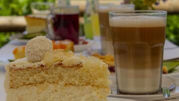 A slice of cake on a plate with a glass of beer in the background.