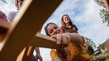Un grupo de personas sentadas al aire libre con una estructura de madera al frente.