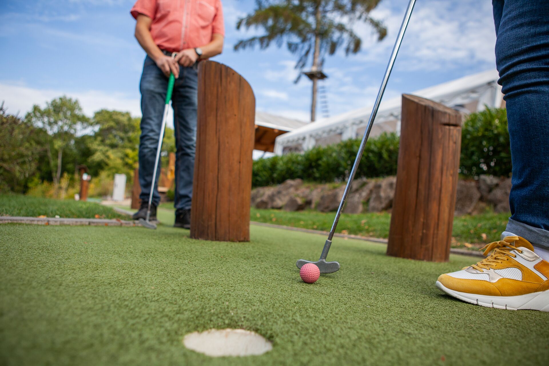Pienoisgolfkenttä, jossa on lyöntialue, golfpallo ja golfmaila.