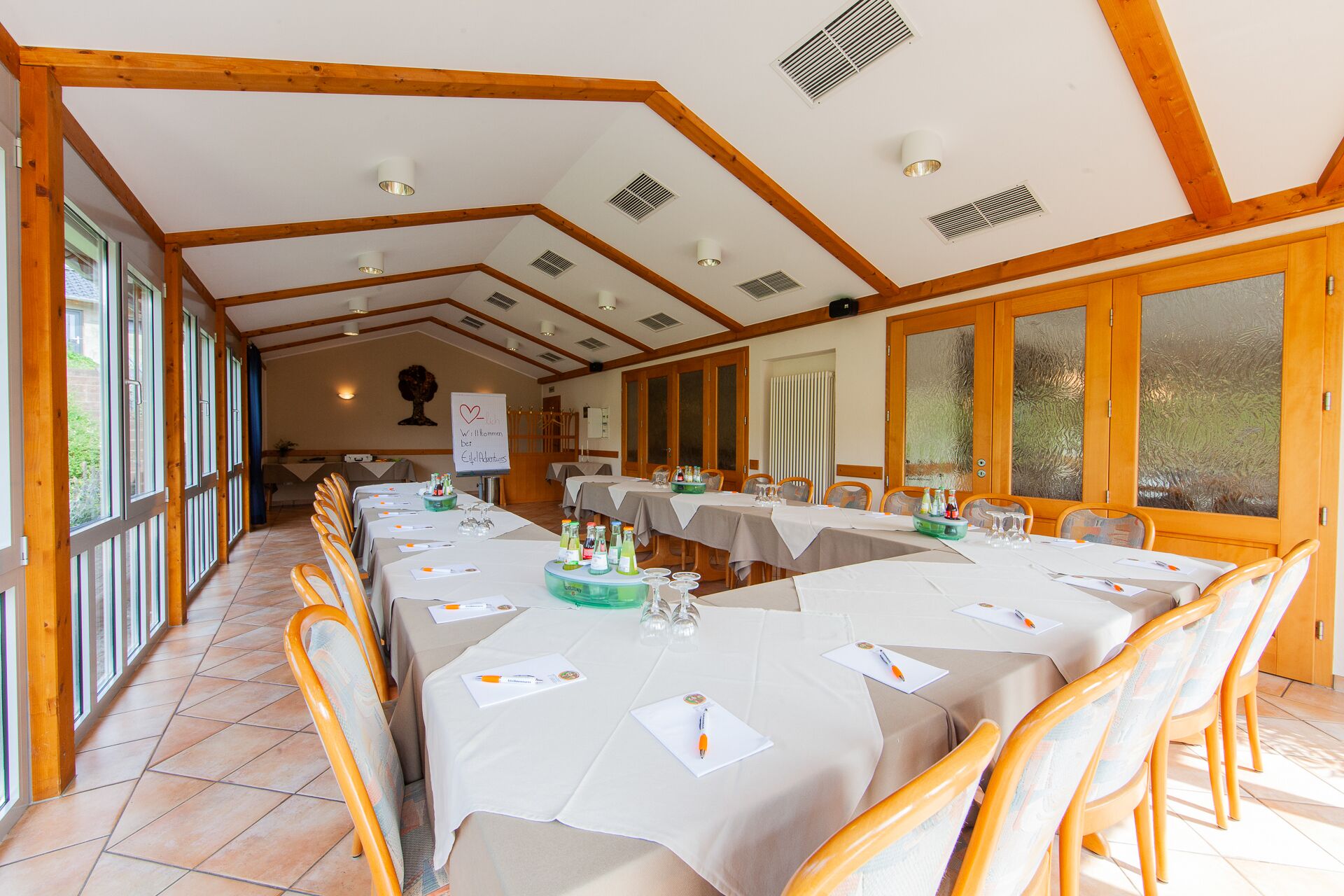 Un salón de conferencias con varias mesas, sillas y una pizarra.