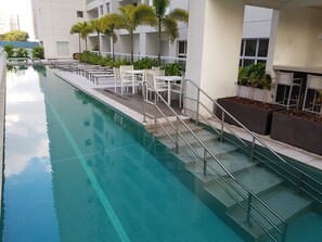 Una piscina al aire libre, sombrillas, tumbonas