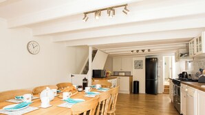 A spacious kitchen with wooden flooring, a dining table set for four, and a microwave on the counter. - 4 bedroom accommodation in Kirkcudbright (Kirkcudbright)