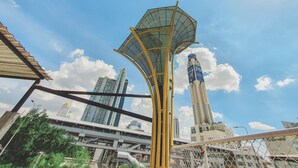 A modern urban scene with a prominent tall building featuring a blue and white advertisement. - Hotel Ordinary Bangkok (Bangkok)