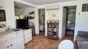 A compact living space with a kitchenette, a dining area, and a small seating area.
