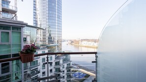 A high-rise building with a view of a river and other buildings. - River View Apartment (London)