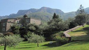 A stone building with a garden and a stone wall.